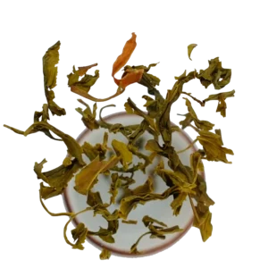 zelený čaj s magnólií, který padá do šálku. Kvalitní zelený čaj z Dobré Čajovny.