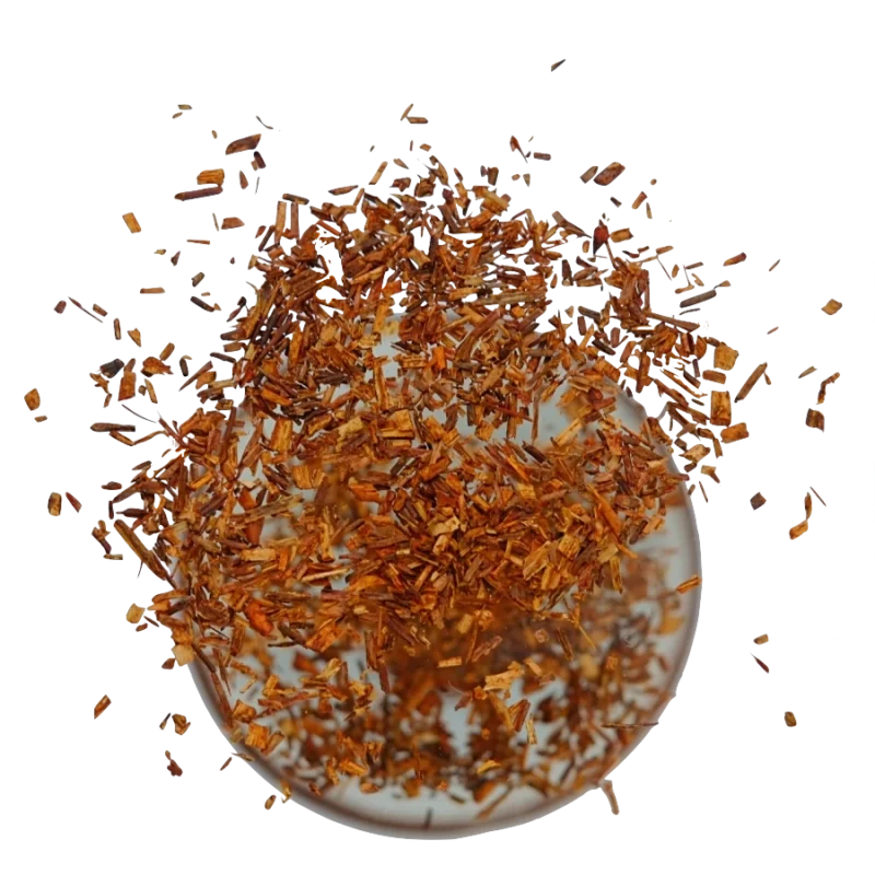 Rooibos neboli čajovec kapský bez kofeinu, který padá do hrnku.